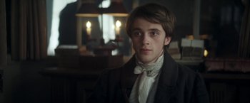 Movie still from “Lost Illusions” (2021), directed by Xavier Giannoli – A young man wearing a suit and a tie; Close Up shot, Over the shoulder angle