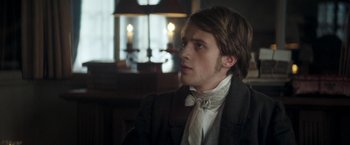 Movie still from “Lost Illusions” (2021), directed by Xavier Giannoli – A young man in a suit and bow tie looking to his left; Close Up shot, Over the shoulder angle