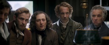 Movie still from “Lost Illusions” (2021), directed by Xavier Giannoli – A man and a woman standing next to each other in a room; Medium shot, Low angle