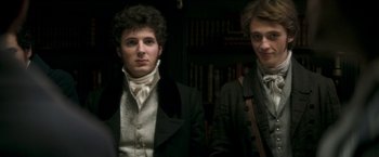 Movie still from “Lost Illusions” (2021), directed by Xavier Giannoli – Two young men dressed in period clothing standing next to each other; Medium shot, Low angle