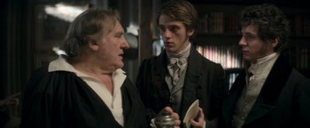 Movie still from “Lost Illusions” (2021), directed by Xavier Giannoli – A man and a man in a suit and tie talking to each other; Medium shot, Over the shoulder angle