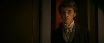 Movie still from “Lost Illusions” (2021), directed by Xavier Giannoli – A young man in a suit and a white tie; Close Up shot, Over the shoulder angle