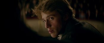 Movie still from “Lost Illusions” (2021), directed by Xavier Giannoli – A young man is looking into the distance; Close Up shot, Over the shoulder angle