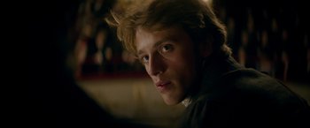 Movie still from “Lost Illusions” (2021), directed by Xavier Giannoli – A young man is looking into the camera; Close Up shot, Over the shoulder angle