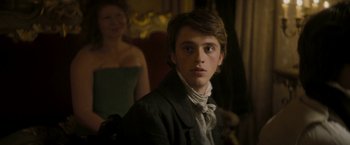 Movie still from “Lost Illusions” (2021), directed by Xavier Giannoli – A young man in a black jacket and a woman in a white dress; Close Up shot, Over the shoulder angle