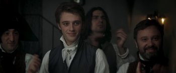 Movie still from “Lost Illusions” (2021), directed by Xavier Giannoli – A man in a vest and a man with long black hair; Close Up shot, Over the shoulder angle