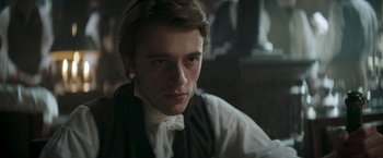 Movie still from “Lost Illusions” (2021), directed by Xavier Giannoli – A young man wearing a white shirt and a black vest; Close Up shot, Over the shoulder angle