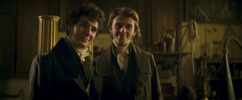 Movie still from “Lost Illusions” (2021), directed by Xavier Giannoli – Two young men standing next to each other in a room; Medium shot, Low angle