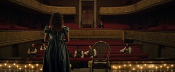 Movie still from “Lost Illusions” (2021), directed by Xavier Giannoli – A little girl standing in front of a group of people in a theater; Wide shot, High angle
