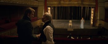 Movie still from “Lost Illusions” (2021), directed by Xavier Giannoli – Two men are talking in an old theater; Medium shot, Over the shoulder angle