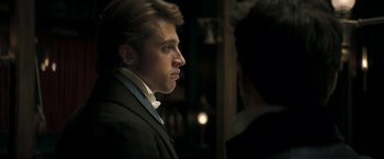 Movie still from “Lost Illusions” (2021), directed by Xavier Giannoli – A man in a suit and tie looking at a woman in a suit; Close Up shot, Over the shoulder angle