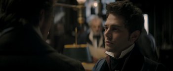 Movie still from “Lost Illusions” (2021), directed by Xavier Giannoli – A man in a suit and tie looking off into the distance; Close Up shot, Over the shoulder angle