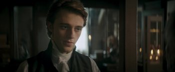 Movie still from “Lost Illusions” (2021), directed by Xavier Giannoli – A young man wearing a black vest and a white shirt; Close Up shot, Over the shoulder angle