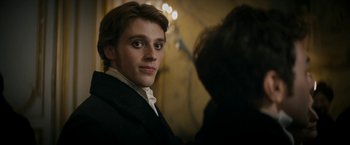 Movie still from “Lost Illusions” (2021), directed by Xavier Giannoli – A young man in a suit and white shirt; Close Up shot, Over the shoulder angle