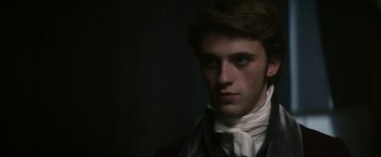 Movie still from “Lost Illusions” (2021), directed by Xavier Giannoli – A young man wearing a suit and a white neck tie; Close Up shot, Over the shoulder angle