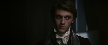 Movie still from “Lost Illusions” (2021), directed by Xavier Giannoli – A young man wearing a white shirt and a black tie; Close Up shot, Over the shoulder angle