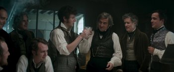 Movie still from “Lost Illusions” (2021), directed by Xavier Giannoli – A man and a man holding a wine glass; Medium shot, Over the shoulder angle