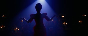 A woman in a red dress in front of an audience