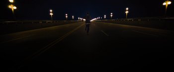 A man is running down the street at night