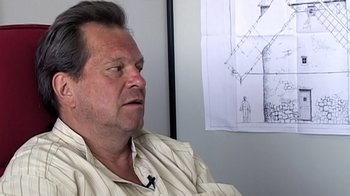 Movie still from “Lost in La Mancha” (2002), directed by Louis Pepe – A person sitting in front of a drawing; Close Up shot, Over the shoulder angle