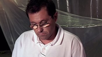 Movie still from “Lost in La Mancha” (2002), directed by Louis Pepe – A person wearing glasses and a white shirt; Close Up shot, Low angle