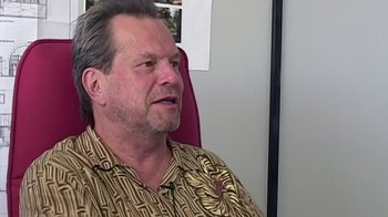 Movie still from “Lost in La Mancha” (2002), directed by Louis Pepe – An older man sitting in an office chair; Close Up shot, Low angle