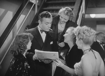 Movie still from “Love Affair” (1939), directed by Leo McCarey – A group of people standing around each other in a room; Medium shot, High angle