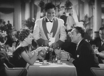 Movie still from “Love Affair” (1939), directed by Leo McCarey – Two men and a woman sitting at a dinner table; Medium shot, High angle
