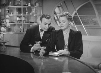 Movie still from “Love Affair” (1939), directed by Leo McCarey – A man and a woman sitting at a table with drinks; Medium shot, High angle