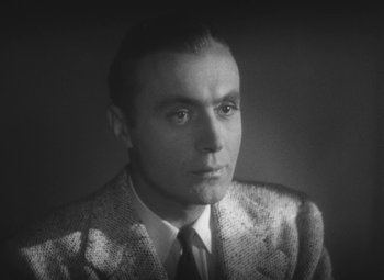 Movie still from “Love Affair” (1939), directed by Leo McCarey – A man wearing a suit and tie in a black and white photo; Close Up shot, High angle