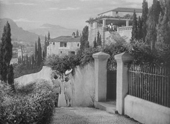 Movie still from “Love Affair” (1939), directed by Leo McCarey – A black - and - white photo of two people walking down a sidewalk; Extreme Wide shot, High angle