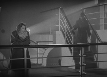 Movie still from “Love Affair” (1939), directed by Leo McCarey – A woman standing on a staircase next to a man; Wide shot, High angle