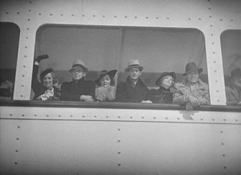 Movie still from “Love Affair” (1939), directed by Leo McCarey – A group of people sitting in the window of an airplane; Medium shot, Overhead angle