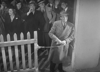 Movie still from “Love Affair” (1939), directed by Leo McCarey – An old black and white photo of a man holding a rope; Wide shot, High angle