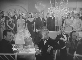 Movie still from “Love Affair” (1939), directed by Leo McCarey – A black and white photo of a group of people in formal wear; Wide shot, Low angle