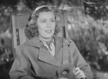 Movie still from “Love Affair” (1939), directed by Leo McCarey – A woman sitting in a chair holding a guitar; Close Up shot, High angle