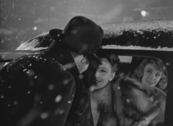 Movie still from “Love Affair” (1939), directed by Leo McCarey – A black and white photo of people in a car in the snow; Medium shot, Over the shoulder angle