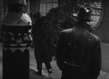 Movie still from “Love Affair” (1939), directed by Leo McCarey – A man in a hat is walking in the snow; Medium shot, Over the shoulder angle