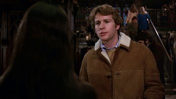 Movie still from “Love Story” (1970), directed by Arthur Hiller – A man in a brown jacket talking to a woman; Close Up shot, Over the shoulder angle