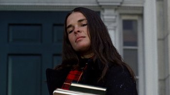 Movie still from “Love Story” (1970), directed by Arthur Hiller – A woman with long black hair is holding a book; Close Up shot, Low angle