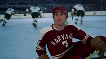 Movie still from “Love Story” (1970), directed by Arthur Hiller – A man in a harvard hockey uniform sitting on the ice; Medium shot, Low angle