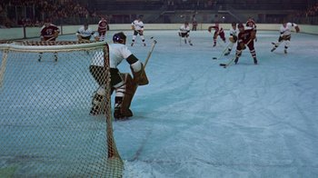 Movie still from “Love Story” (1970), directed by Arthur Hiller – A group of men playing a game of ice hockey; Wide shot, High angle