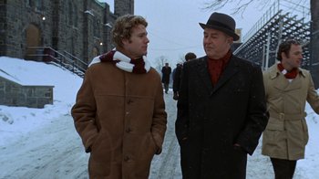 Movie still from “Love Story” (1970), directed by Arthur Hiller – Two men standing next to each other on a snowy day; Medium shot, Low angle