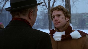 Movie still from “Love Story” (1970), directed by Arthur Hiller – A man wearing a hat and a scarf talking to another man; Close Up shot, Over the shoulder angle