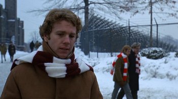 Movie still from “Love Story” (1970), directed by Arthur Hiller – A man in a brown coat and a red and white striped scarf; Close Up shot, Over the shoulder angle