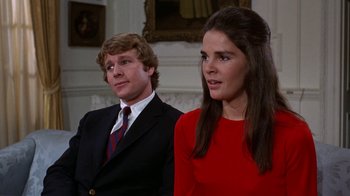 Movie still from “Love Story” (1970), directed by Arthur Hiller – A man and a woman standing next to each other in a room; Close Up shot, Low angle