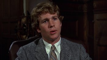 Movie still from “Love Story” (1970), directed by Arthur Hiller – A person wearing a suit and a tie; Close Up shot, Low angle