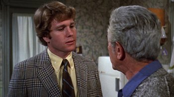 Movie still from “Love Story” (1970), directed by Arthur Hiller – A man wearing a suit and tie talking to another man wearing a suit and tie; Close Up shot, Over the shoulder angle