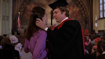 Movie still from “Love Story” (1970), directed by Arthur Hiller – A man and a woman in graduation attire; Medium shot, Low angle