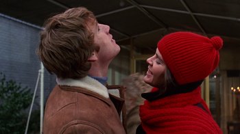 Movie still from “Love Story” (1970), directed by Arthur Hiller – A man and a woman standing next to each other; Close Up shot, Low angle
